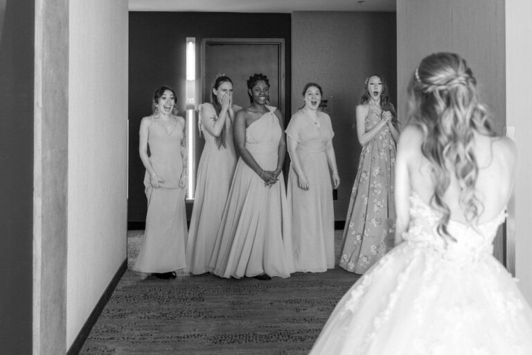 First look de mariage : les demoiselles d'honneur découvrent la mariée, photo en noir et blanc